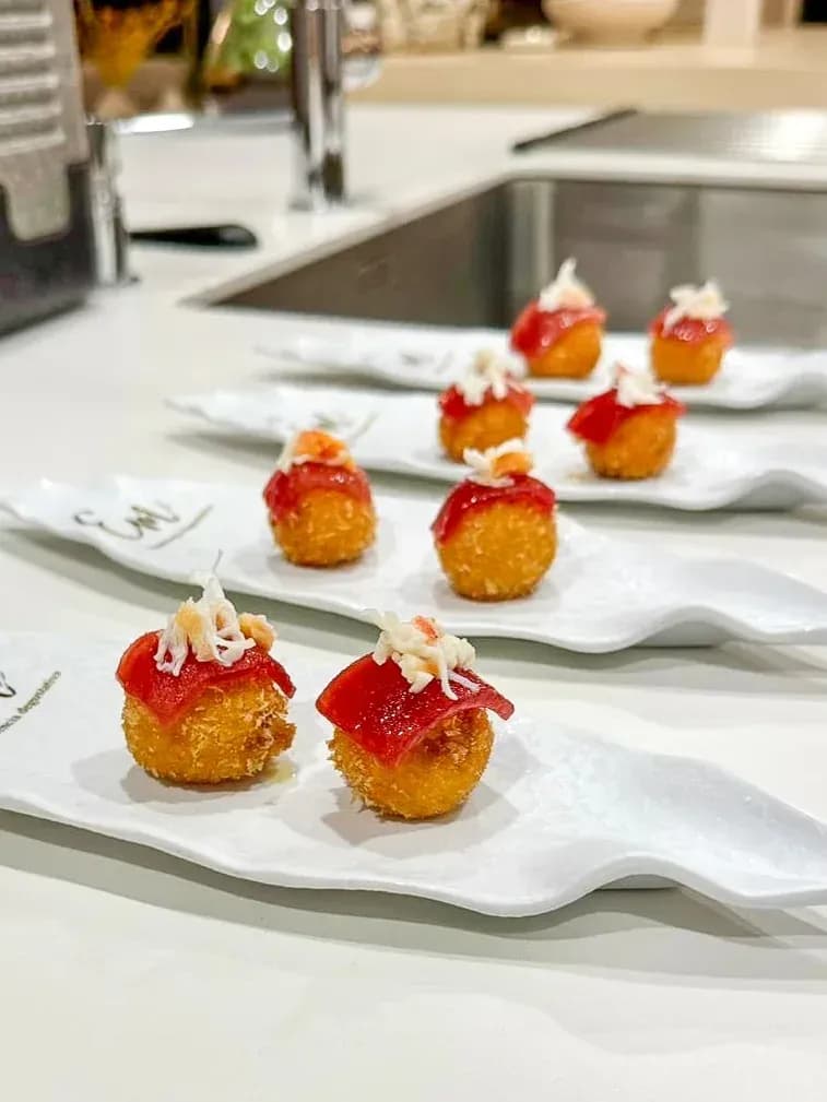 Croqueta de carabinero con tomate seco, lámina de atún rojo coronada con cangrejo blanco